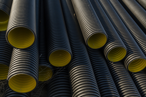 Black corrugated plastic pipe on construction site. Pipes for us
